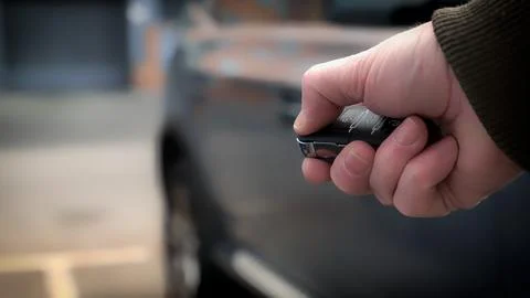 Man using remote control to open car Stock Photos