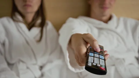 Man Using Remote Control Switching Channels in Hotel Room Stock-Footage 345840245