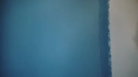 Man using roller painter on a blue wall Stock Footage 68800322