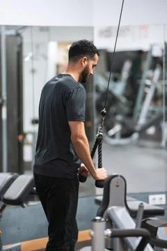 Man using a rope tricep pushdown machine at the gym. 스톡 사진