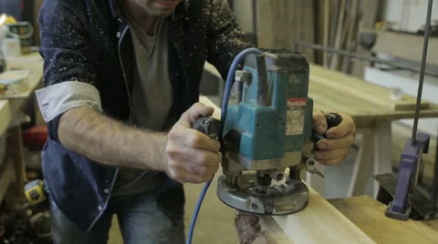 Man using a router on a piece of wood in a workshop Stock Footage 58930319