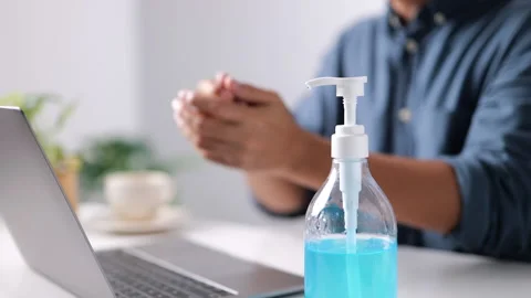 Man using sanitizer alcohol bottle of antibacterial on office desk with laptop Video stock 162706969