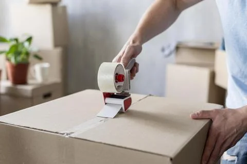 Man using scotch tape box ready moving out . High quality and resolution Stock Photos