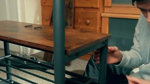 Man using screwdriver to secure wooden shelf on coat rack. Male assembling Stock Footage 309397924