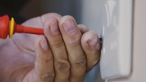Man using screwdriver to tighten an electrical socket Stock Footage 77679227