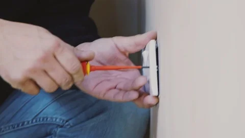 Man using screwdriver to tighten an electrical socket Stock Footage 77679815