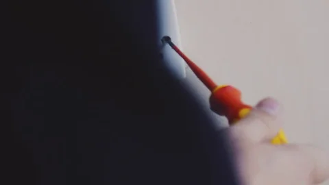 Man using screwdriver to tighten an electrical socket Stock Footage 77680288