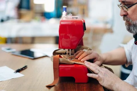Man using sewing machine in creative studio Stock Photos