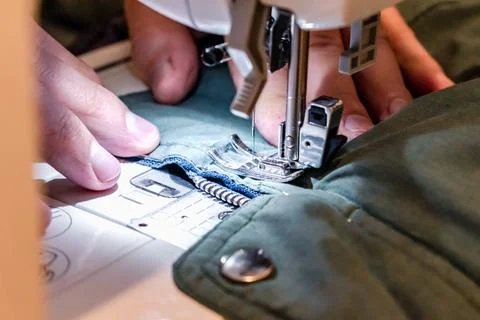 Man using a sewing machine with a garment, for repair work, customization, .. Stockfoto's