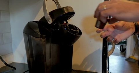 Man using a single serving pod coffee maker to brew a cup of coffee Stockbeeldmateriaal 109306510