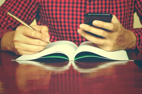 Man using smarphone make note about expenses at home. Stock Photos