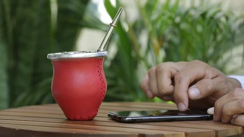 Man using smart phone and drinking yerba mate tea Stock Footage 127796537