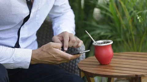 Man using smart phone and drinking yerba mate tea. Slow Motion. Stock Footage 127796579