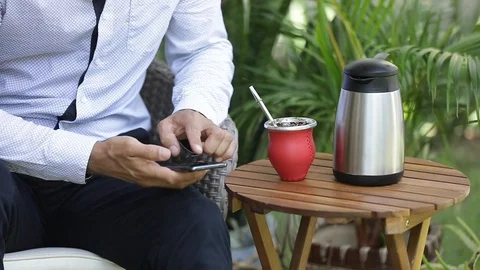Man using smart phone and drinking yerba mate tea Stock Footage 127796614