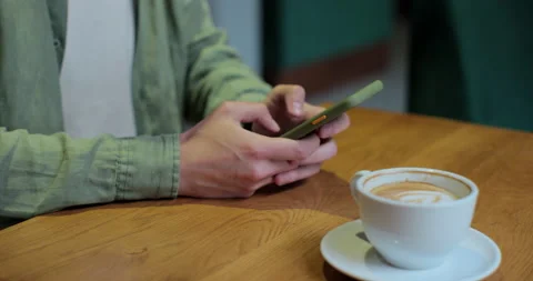 Man using smart phone in coffee shop. Male using phone drinking coffee at coffee Stock Footage 197601742