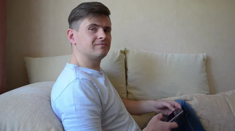 Man using smart phone at home sitting in the sofa Stock-Footage 60762659