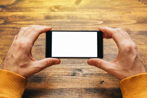 Man using smart phone in horizontal landscape orientation Stock Photos