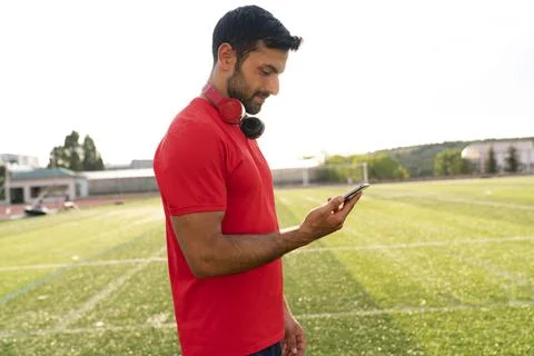 Man using smart phone inside city park after exercising outdoor. Stock Photos