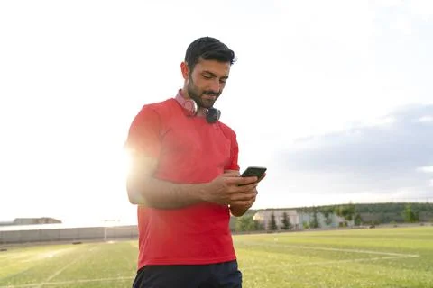 Man using smart phone inside city park after exercising outdoor. Stock Photos