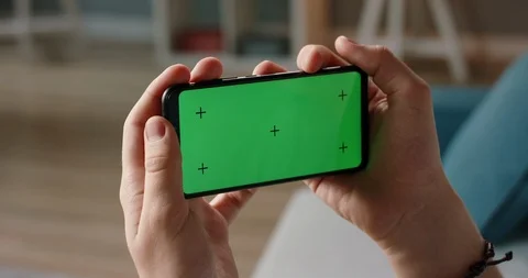 Man using a smart phone with mock up green screen, talking while having an Stock Footage 127469194