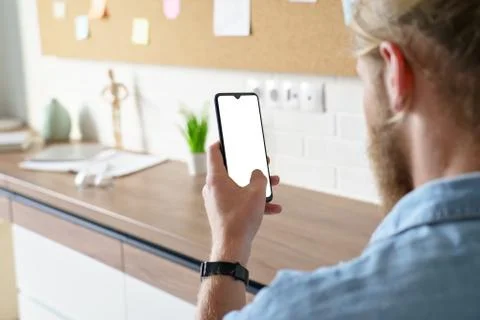 Man using smart phone mock up white screen, over shoulder view. Stock Photos