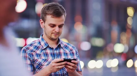 Man using smart phone at night in city. 4K. Busy Street lights background. Stock-Footage 67847233