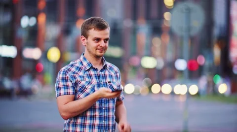 Man using smart phone at night in city. 4K. Busy Street lights background. Видео 67847467
