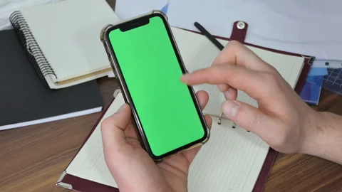 Man using smart phone in office space, sitting on chair and using green screen Stock Footage 190000028