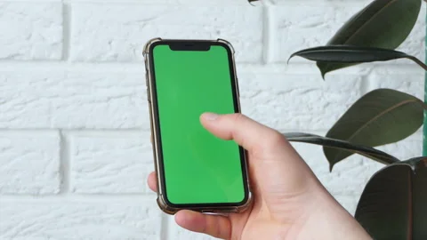 Man using smart phone in office space, sitting on chair and using green screen Stock Footage 190007549