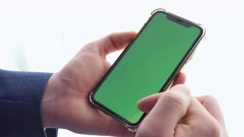 Man using smart phone in office space, sitting on chair and using green screen Stock Footage 191544643