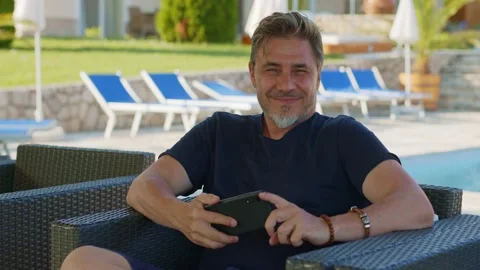 Man using smart phone outdoor on vacation in hotel garden Stock Footage 162683363