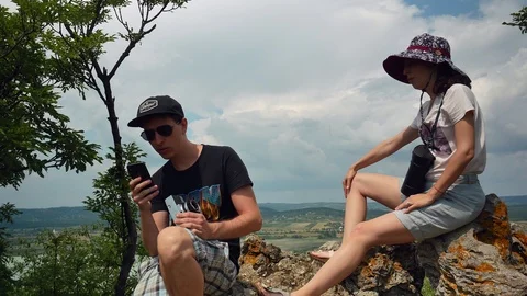 Man using smart phone outside summer sunshine nature next to girlfriend Stockbeeldmateriaal 116098151