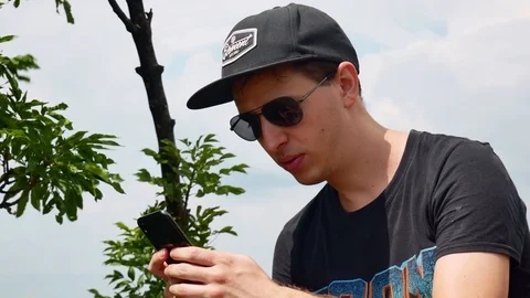 Man using smart phone outside summer sunshine nature background looking screen Stock Footage 116098305