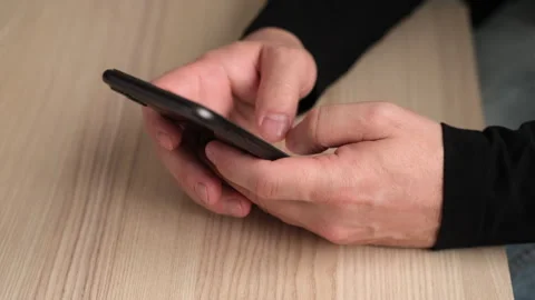 Man using smart phone, typing text or shopping online, reading news on internet Stock Footage 247236300