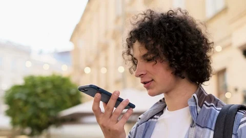 Man using a smart phone voice recognition function online walking on a city 스톡 동영상 101071842