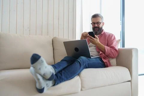Man using smart thermostat, adjusting, lowering heating temperature at home. Man Stock Photos