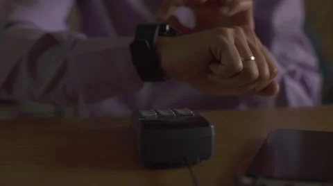 Man using smart watch to express pay on a wooden table Video stock 67566550