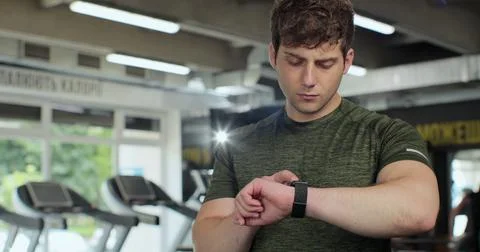 Man using a smart watch in gym. Sportive man checking pulse in smartwatch after Foto stock