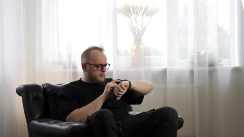 Man Using Smart Watch in Relaxed Indoor Setting Stock Footage 333362759