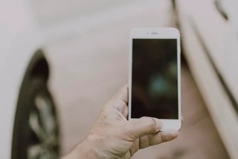 Man using smartphone at abstract blurred street night. Black screen for graph Stock Photos