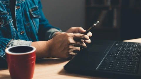 Man using smartphone and computer laptop. which is payment online, sits on .. Stock Photos