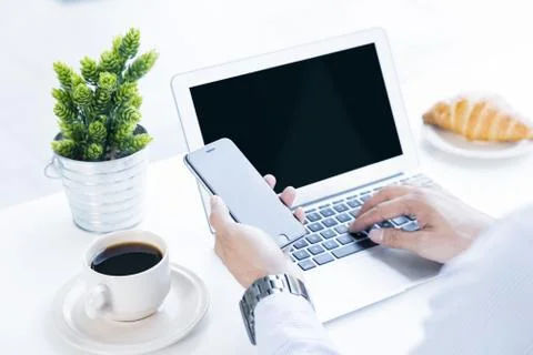 Man using a smartphone and a laptop Stock Photos