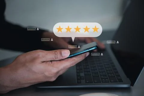 Man using smartphone and laptop computer to rate and evaluate services Stock Photos