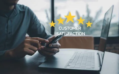 Man using smartphone and laptop computer to rate and evaluate services Stock Photos