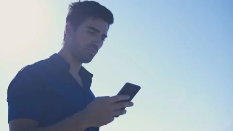 Man using smartphone and making phone call against blue sky Stock-Footage 133261651