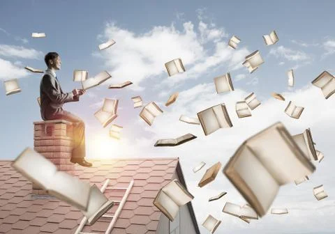 Man using smartphone and many books flying in air Fotos de archivo