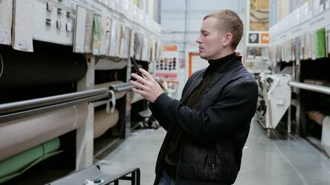 Man using smartphone app to browse and select carpets for renovation project in Stock Photos