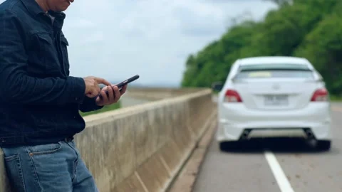 A man is using a smartphone to ask for help as his car is parked Stock-Footage 147976056