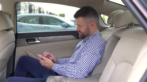 Man using smartphone in back seat of luxury car Stock Footage 200953550