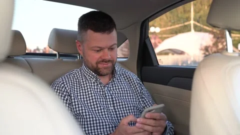 Man using smartphone in back seat of luxury car Stock Footage 204942268